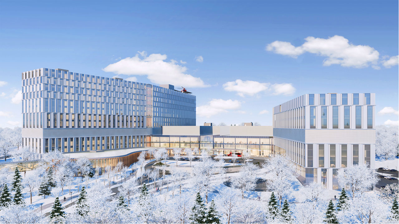 An artist rendering of the exterior of the new hospital on a winter day, showing snow-covered trees in the foreground. A helicopter is on the helipad on the roof of the building. 