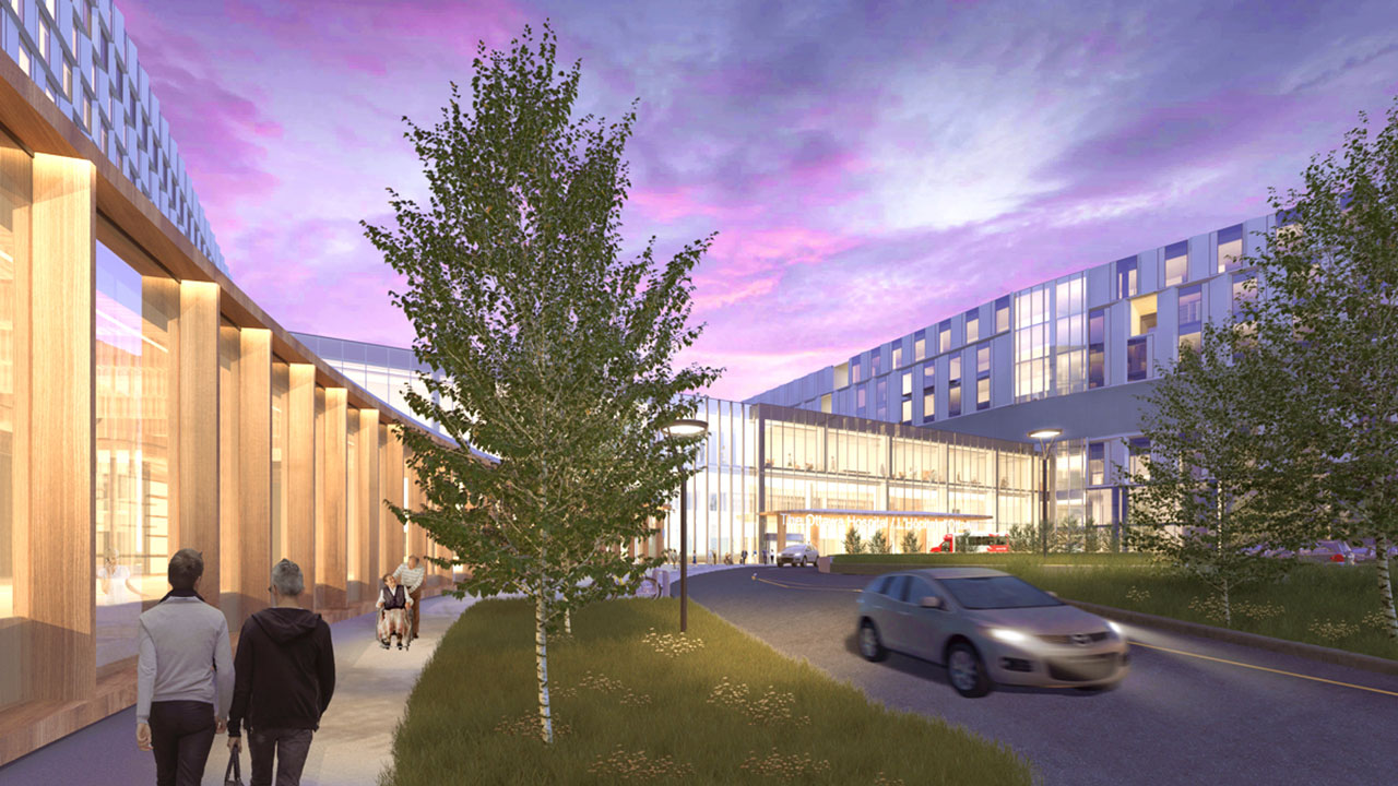 An artist rendering of the new hospital’s main entrance at dusk. A car is driving through the roundabout while people are walking and using wheelchairs on the sidewalk in front of the building. Grass and trees are part of the natural landscape in front of the entrance. 