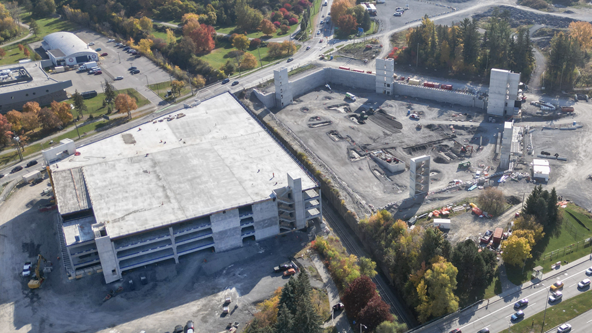 An aerial view in the fall of the partially constructed parking garage at The Ottawa Hospital’s new campus. One half of the parking garage is completed, it has multiple levels and is covered by a roof.