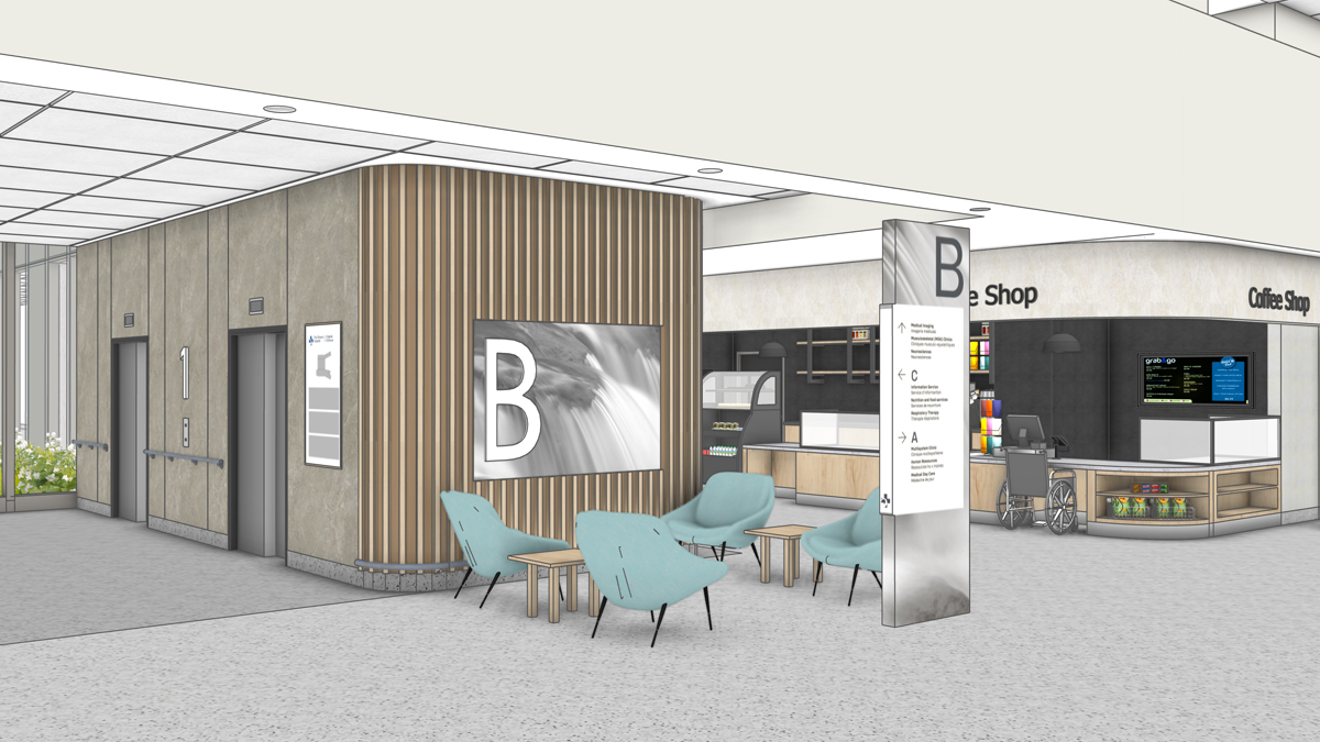 An artist rendering of a close-up perspective of a bank of elevators and a coffee shop inside the main entrance of a new hospital. On the left are two elevator doors with the number 1 on the wall between them. A large letter B is on a sign on the wall around the corner from the elevator doors, with 4 green chairs in front of it. The coffee shop is in the background right with the words “Coffee Shop” on the wall above it. A small vertical sign with the letters B, C and A and arrows with directions is in the foreground.