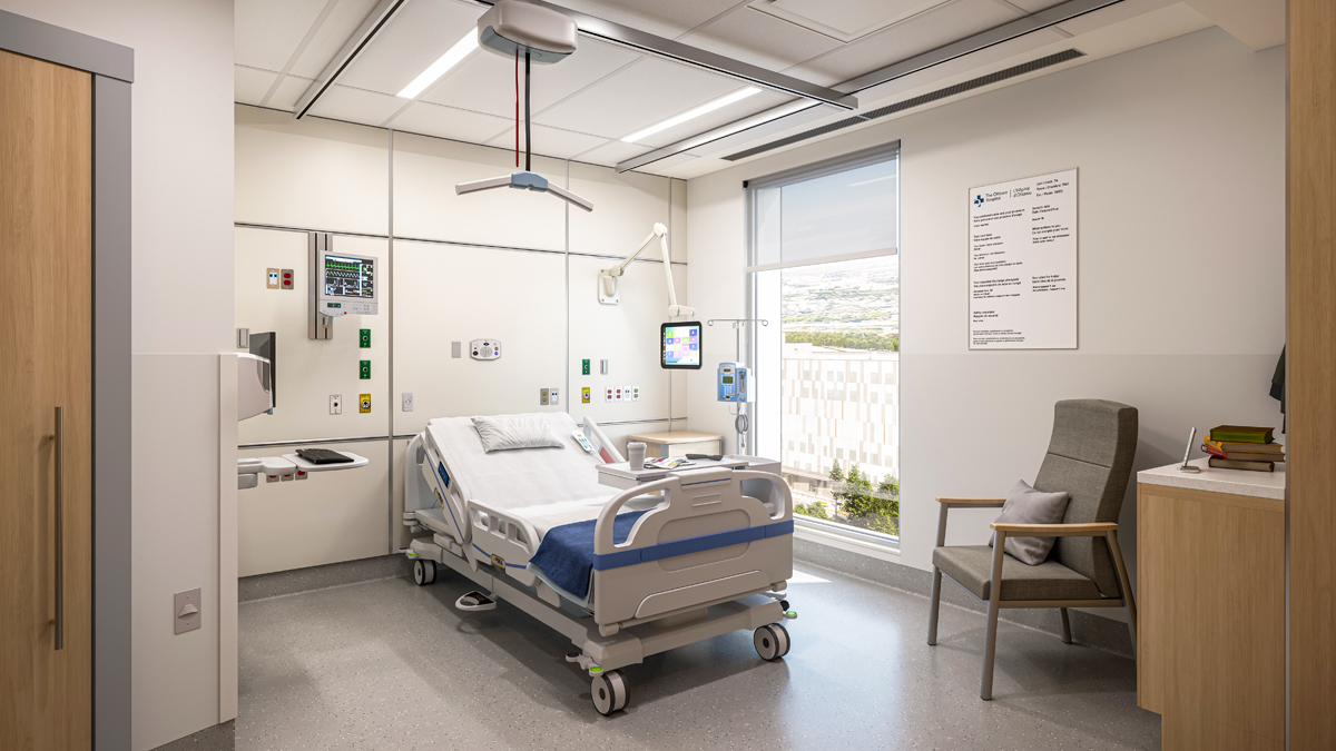 An artist rendering of the inside of a patient room at The Ottawa Hospital’s new campus. An empty patient bed and various pieces of hospital equipment are in the middle. A door to a bathroom is on the left, and a large window to the right of the bed provides a clear view outdoors. There is a chair next to a small countertop with books on it at the far right.